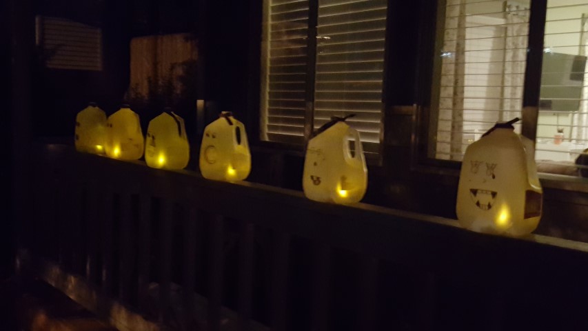 The girls made glowing ghosts out of milk cartons for the porch